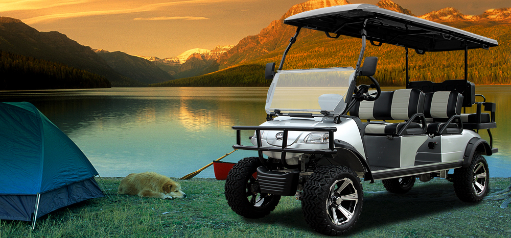 Evolution Golf Cart next to tent with lake and mountains in the background with a beautiful sunset.